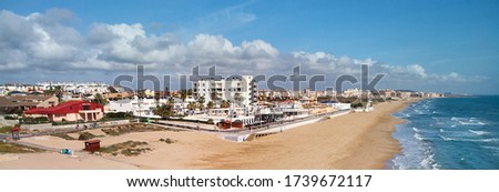 Aerial horizontal photography empty sandy coastline of Costa Blanca at sunny day. Mediterranean Sea surf water blue cloudy sky, picturesque scenery, due coronavirus all beaches are closed. Spain