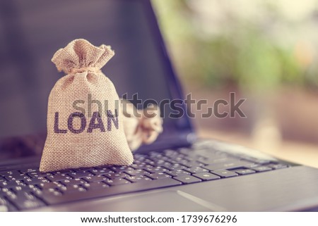 Online personal loan, financial concept : Loan bags on a laptop, depicting peer-to-peer lending, the practice of lending money to individual or business via online service among lenders and borrowers Royalty-Free Stock Photo #1739676296