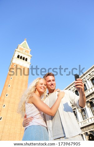 Couple taking selfie picture on travel in Venice in Love. Romantic couple on Piazza San Marco. Young couple on vacation holidays having fun on St Mark's Square, Venice, Italy. Beautiful woman and man.