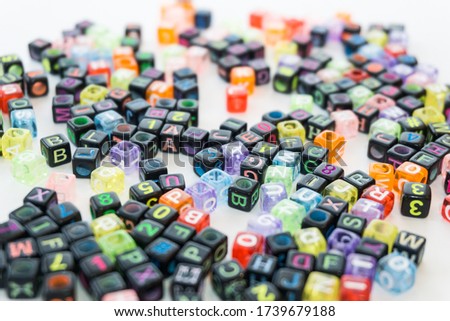 Colorful alphabets beads on white background, different colors with letters, concept image