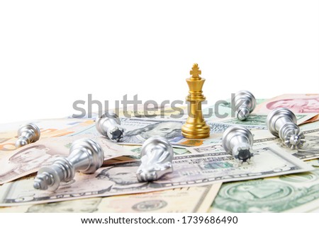 Gold king chess standing on international banknote on white background with another chess failing on bankbote, chess and banknote on white background for abstract and business management 