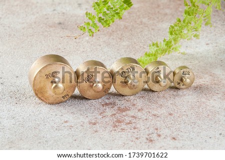 Five antique bronze weights for scales on concrete background. Copy space for text and food photography props.