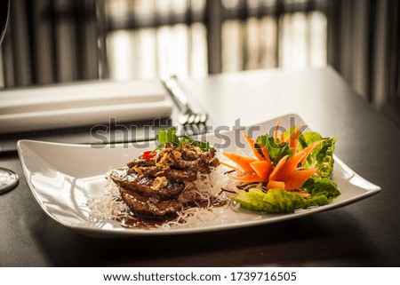 Duck with tamarind sauce on a bed of crispy rice noodle.