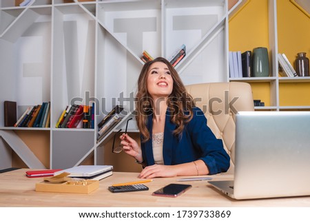 businesswoman working in office with laptop, at her desk