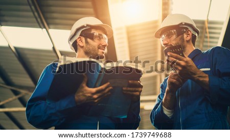 The Industrial workers discuss the spare parts of the machine in factory with a manual guide book, the procedure of work in the factory, concept industrial workers process, manufacturing operation. Royalty-Free Stock Photo #1739749688