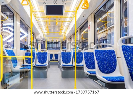 Interior design of a modern bus. Empty bus interior. Public transport in the city. Passenger transportation. Bus with blue seats and yellow handrails. Royalty-Free Stock Photo #1739757167