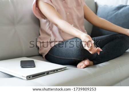 body of woman exercise by pose yoga meditation with turn off computer and mobile phone, self care calm activity at home, social stop or disconnect digital detox concept. Royalty-Free Stock Photo #1739809253