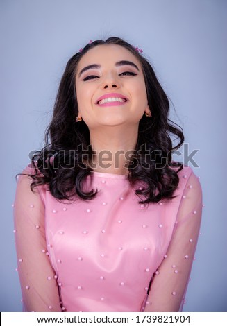 Portrait Of Beautiful Young girle Standing Against blue Background,girl in a pink dress,Happy cheery smiling young cute girl posing isolated