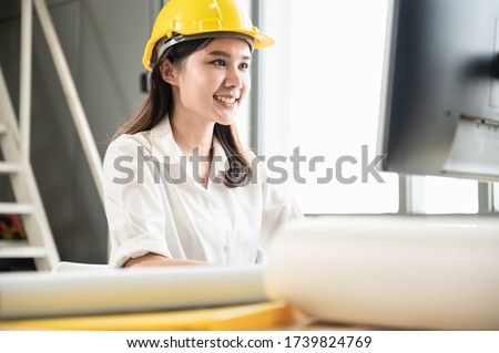 Portrait photo of young beautiful professional look Asian woman construcion worker or engineer working in ofice or indoor  construction site attractively.