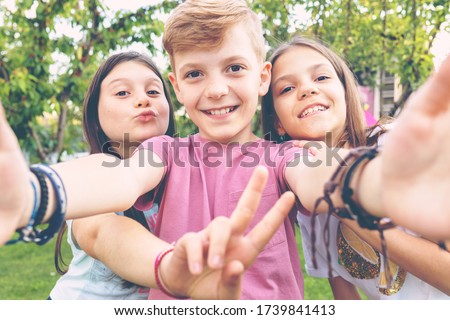 Best friends taking selfie outdoors in backyard – happy friendship with smart kids having fun celebrating summer vacation – modern children enjoying time together at garden party playing and smiling Royalty-Free Stock Photo #1739841413