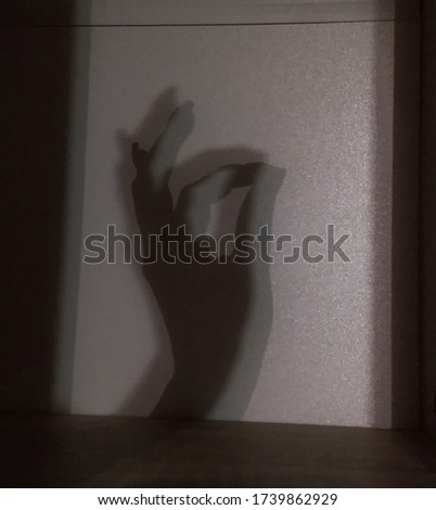 the shadow falls on the wall by hand and fingers show that everything is fine