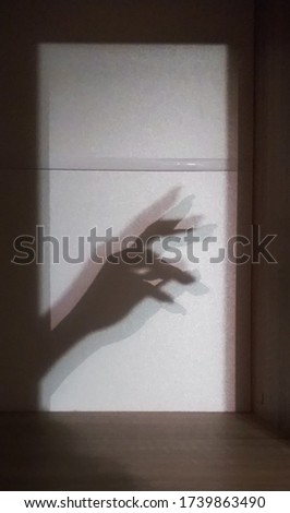 the shadow falls on the wall by hand and fingers show that everything is fine