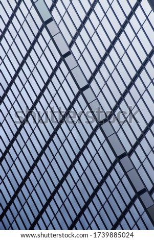 Reworked photo of office building exterior fragment. Structural glazing. Sky reflecting in glass wall. Abstract modern architecture background with rectangular geometric structure.