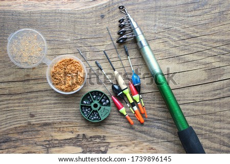 Fishing rods and reels with fishing line on an old wooden background with free space. Floats and other accessories for fishing.