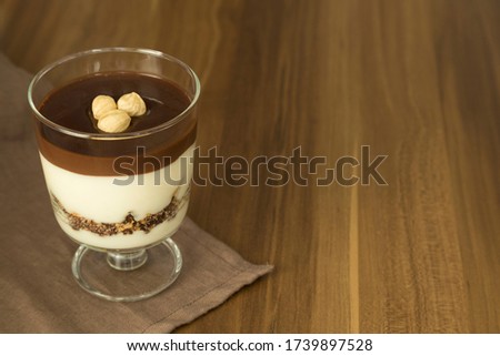 Service chocolate magnolia dessert with hazelnut on the wooden background.