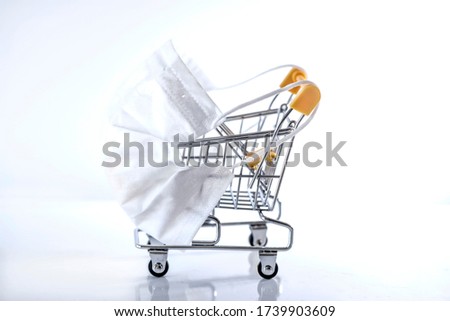 Empty shopping cart wearing a white face mask because of the Covid-19, close up, macro photography
