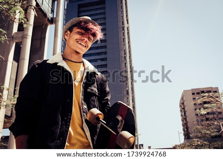 Urban style generation z young teenager portrait with city skyline in bakground - alternative and diversity people concept with handsome coloured hair male - youth lifestyle
