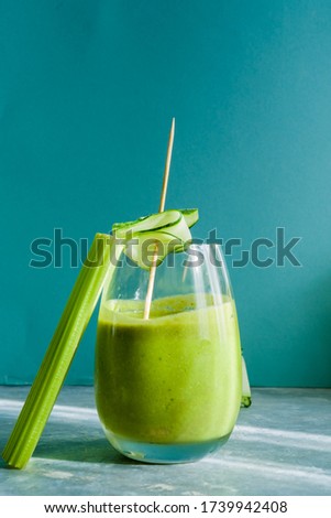 Healthy green smoothie with kale,parsley and banana and in glass against a blue  background. Detox, diet, healthy, vegetarian food concept with copy space.