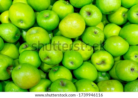 A bunch of light green apples are close-up on a shelf in the store. The concept of the beginning of summer, happiness, useful natural vitamins.