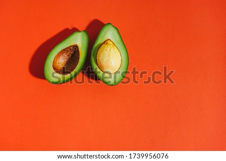 Sliced avocado on an orange background. Flat lay. Top view. Bright picture