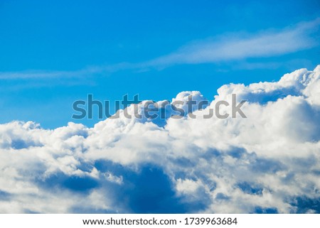 Pure fluffy white clouds on a blue sky. The view from the window of the plane. Background for design.
