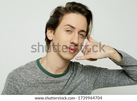 Young attractive guy makes phone sign