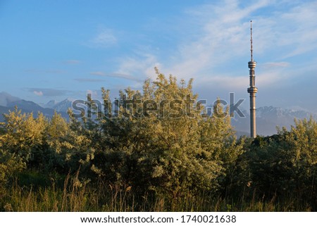 Kok Tobe TV tower, located on a high hill with trees above the city of Almaty, Kazakhstan. Evening time, before sunset