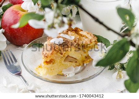 Freshly baked Apple pie on the table with apples, piece in plate