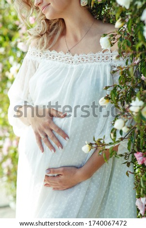 Beautiful pregnant women in nature. Pregnant girl with roses.
