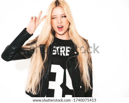 Young beautiful hipster bad girl in black leather jacket and stylish fashionable tight military pants leggings.Model with earring in nose.Sexy carefree  woman posing in studio.Isolated on white Royalty-Free Stock Photo #1740075413