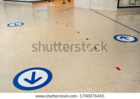 Epidemic protection measures in shops or shopping malls - two way direction for customers. Social Distance Shopping Line Up.  Life after virus. Secure marking of lines on floor for waiting in store. 