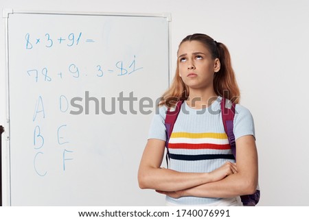 Schoolgirl near the blackboard learning a knowledge lesson