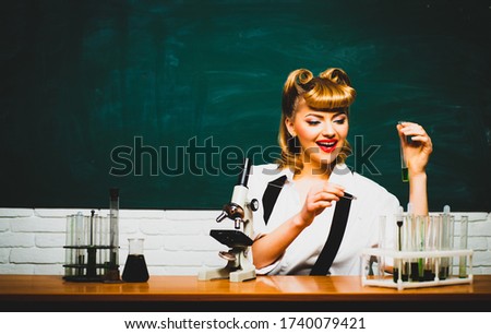 Teacher in quarantine is doing a lesson online. Beautiful woman teaches chemistry at a distance school. Education