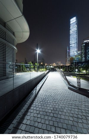Modern pedestrian walkway and skyline of Hong Kong city at night