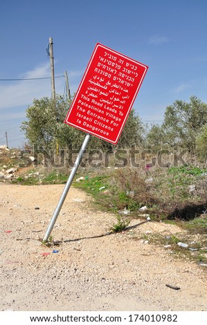 Red signboard warning about entrance to palestinian settlement. Central Israel. 