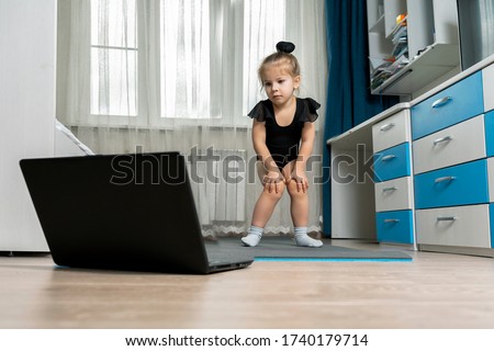 online rhythmic gymnastics. girl preschooler engaged in physical education with a trainer online