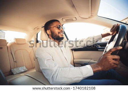 Happy Driver. African Man Driving Own New Car Sitting In Seat And Smiling. Selective Focus Royalty-Free Stock Photo #1740182108