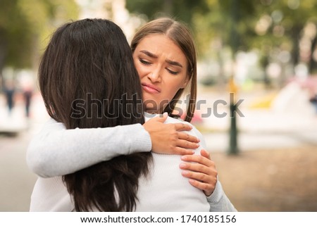 Bad Friend. Disgusted Girl Hugging Crying Girlfriend Pretending To Support Her Standing Outdoors. Free Space Royalty-Free Stock Photo #1740185156