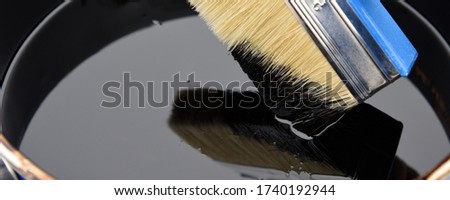 Roofer's hand holding a brush with bituminous mastic. Waterproofing. Waterproofing  insulation of a roof. Royalty-Free Stock Photo #1740192944