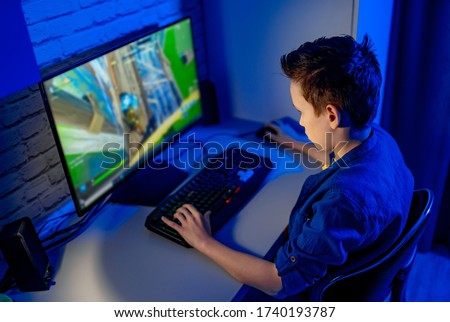 Teenage boy playes videogames. Addicted to video gaming at home Royalty-Free Stock Photo #1740193787
