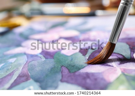 Painting flowers with watercolor on paper, closeup