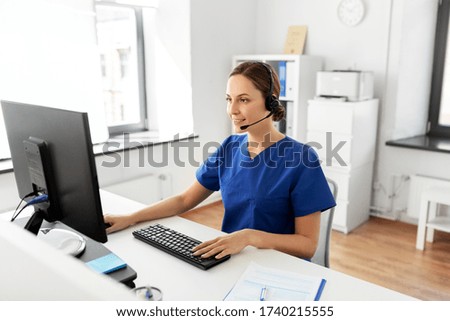 medicine, technology and healthcare concept - happy smiling female doctor or nurse with headset and computer working at hospital Royalty-Free Stock Photo #1740215555