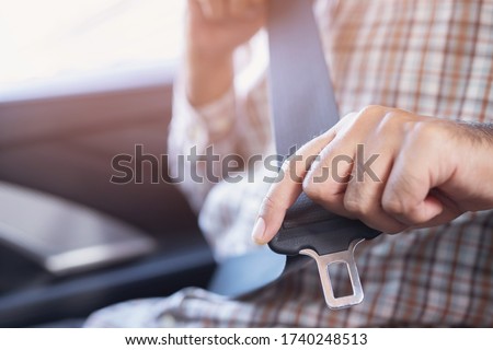 Close Up of people business man hand fastening seat safety belt in car for safety before driving on the road. concept transport travel. soft focus.