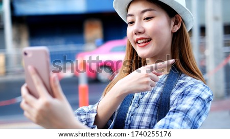 Traveler Asian blogger women travel in Bangkok,beautiful female using mobile phone make vlog and live in social media .woman tourist making video call with smartphone while traveling in Thai temple, 
