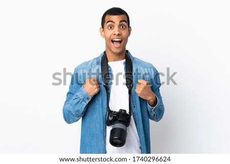 Young African American photographer man over isolated white background celebrating a victory