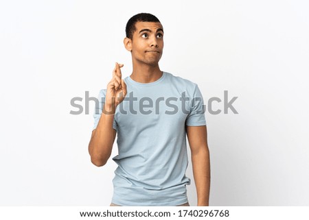 African American man over isolated white background with fingers crossing and wishing the best