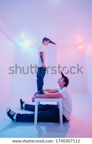 A young married couple of unicorns lives and experiences different emotions in a white room. closeup portrait of a female dominance attempt