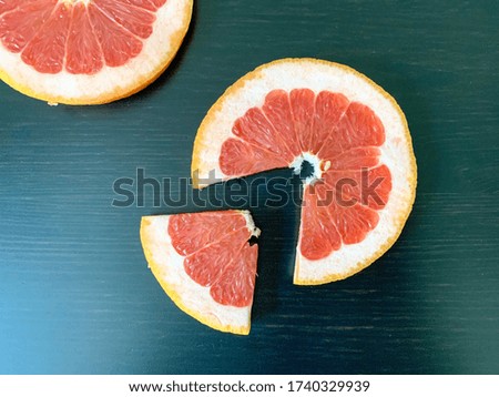 Sliced grapefruit in circles on a black table. Proper nutrition, vitamins, healthy snacks.