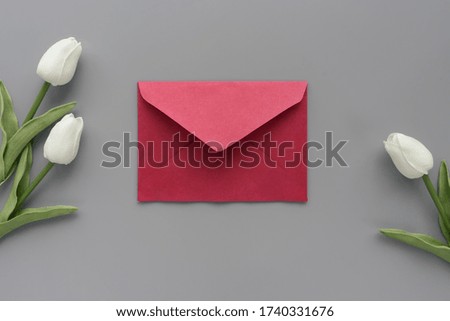 Red letter on grey background with white tulips