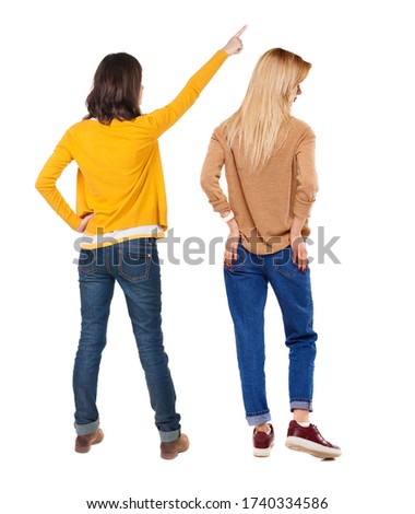 Back view of two young woman photographed on a mobile phone in sweater. Rear view people collection. backside view of person. Rear view. Isolated over white background.